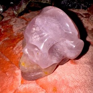 Rose quartz skull wearing headphones